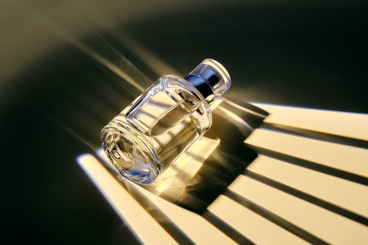 Frasco de perfume iluminado con rayas de sombra